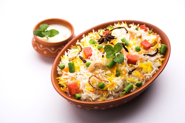 Pulav vegetal indiano ou Biryani feito com arroz Basmati, servido em tigela de terracota. foco seletivo