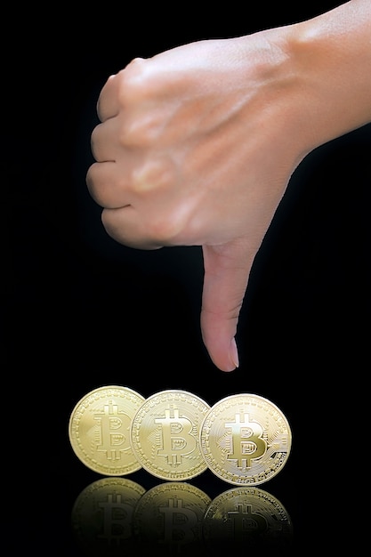 Pulgar hacia abajo signo de mano. bitcoins Bitcoins y nuevo concepto de dinero virtual. Bitcoin es una nueva moneda.