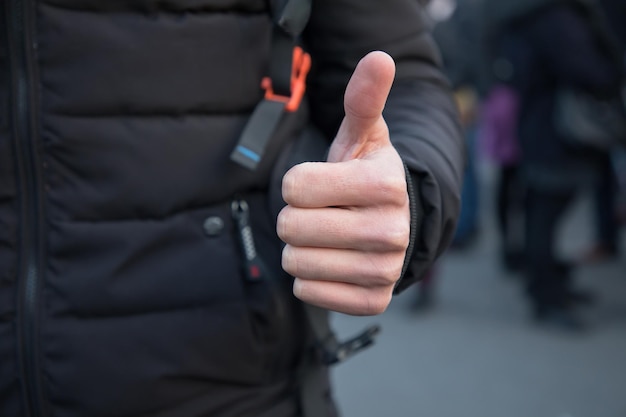 Pulgar de hombre en la calle