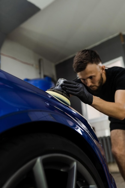 Pulido de coches de cera dura con pulidor orbital para eliminar arañazos proceso de trabajo de primer plano en el detalle del servicio automático