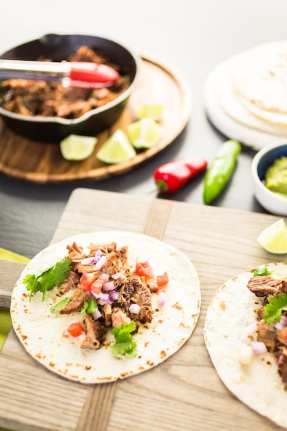 Pulled Pork Carnitas mit Pico de Gallo auf einer Mehltortilla.