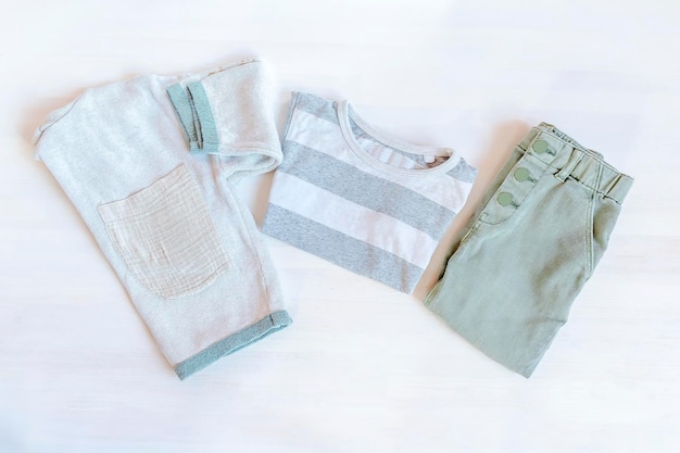 Pullover-Shirt und Jeans-Hose Set mit Baby-Kinderkleidung und Accessoires für Frühling, Herbst oder Sommer auf weißem Hintergrund Mode-Kinder-Outfit Flat Lay Top Viewoverheadmock up