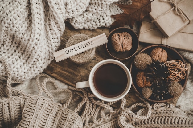 Foto pullover und eine tasse tee mit notizbuch, kerze und strickkleidung