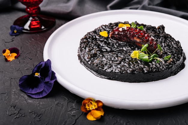 Pulpo cocido y arroz negro en plato