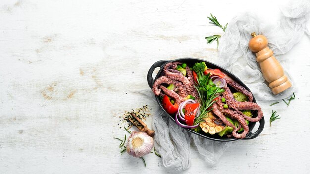 Pulpo grande hervido con verduras a la parrilla en un plato de piedra negra Mariscos Vista superior Espacio libre para su texto