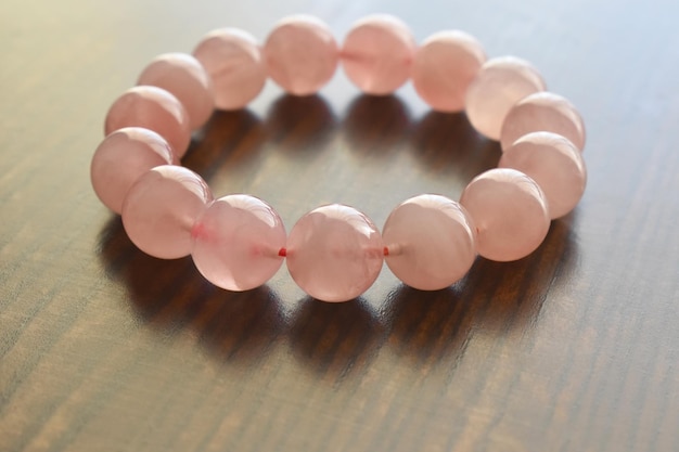 Pulseira de quartzo rosa na mesa de madeira