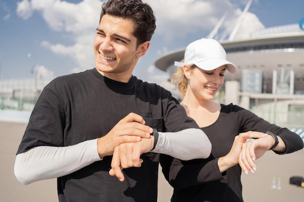 Pulseira de relógio de pulso de aplicativo de fitness em sua mão Homem e mulher treinando correndo no parque