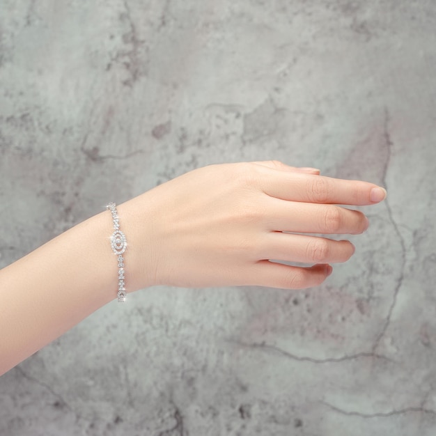 pulseira incrustada com um diamante na mão isolada em fundo cinza