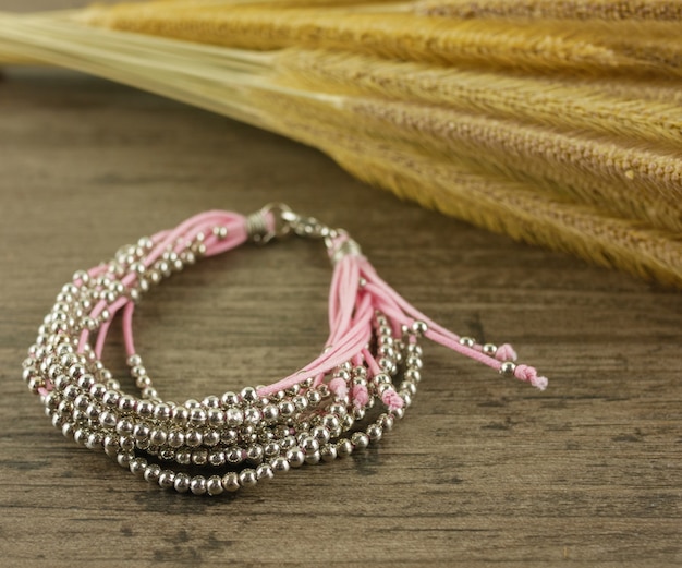 Pulseira rosa multi-strand na mesa de madeira