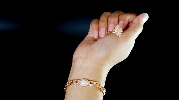 Pulsera y anillo en español para mujer en una mano de mujer.