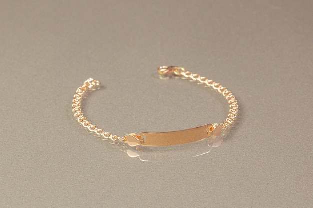 Una pulsera de barra de oro con una pequeña barra de oro.