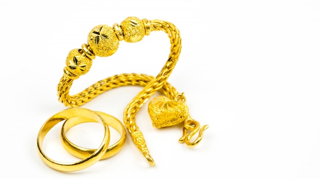 Pulsera de joyas de oro de estilo tailandés y anillo de oro de pareja aislado en blanco con espacio de copia