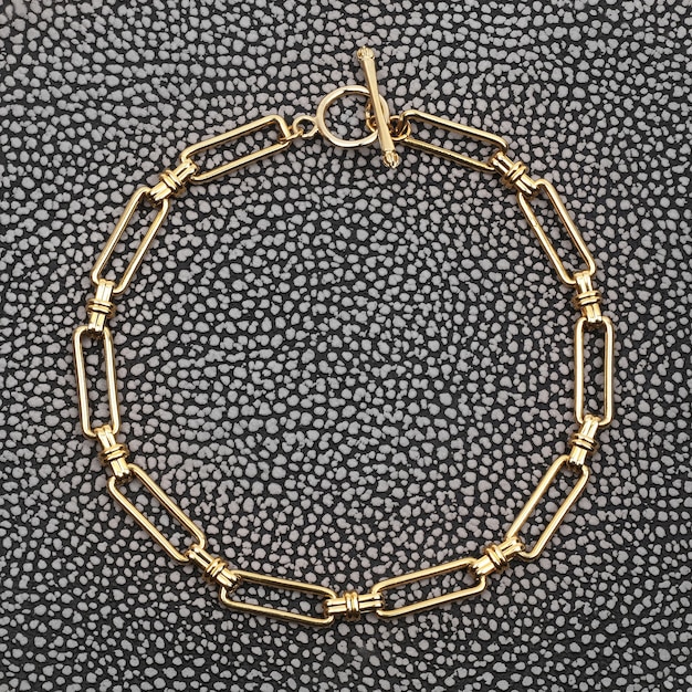 Pulsera de mujer de cadena de oro sobre fondo de cuero manchado