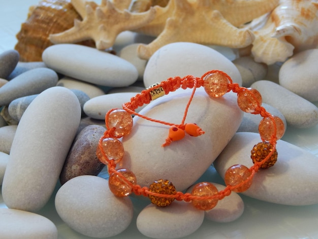 Pulsera naranja y guijarro de mar