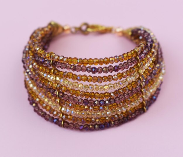 Pulseras hechas de piedras preciosas en un fondo rosado de primer plano