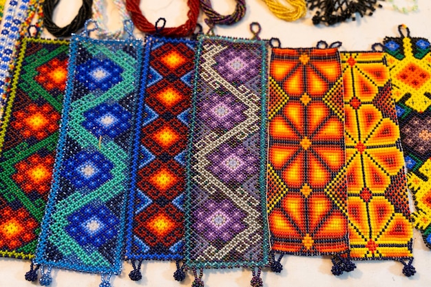 Foto pulseras huicholes hechas a mano con diferentes colores y patrones en el mercado nocturno de guadalajara, méxico