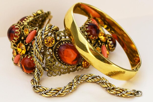 Pulseras de oro con piedras rojas y doradas en un fondo blanco de primer plano