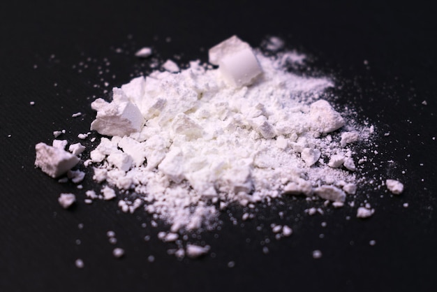 Pulver aus Drogen auf schwarzem Hintergrund Das Konzept des illegalen Handels mit Betäubungsmitteln