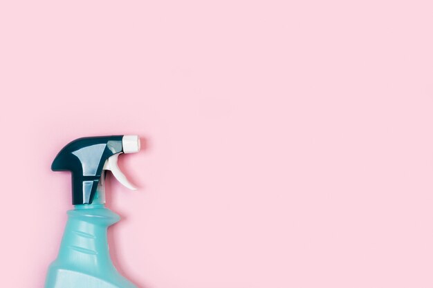 Pulverizador de produtos de limpeza diversos em fundo rosa