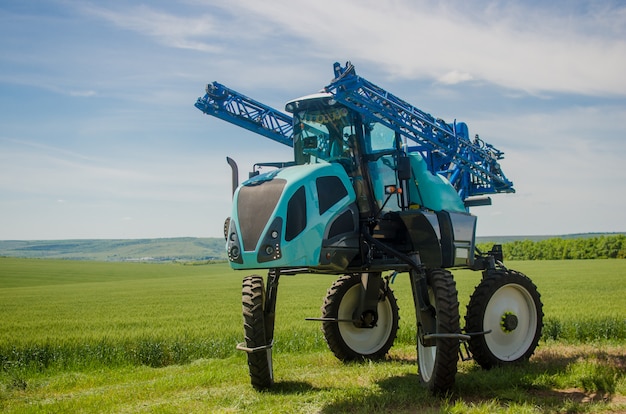 Foto pulverizadores agrícolas, produtos químicos para pulverização de trigo jovem.