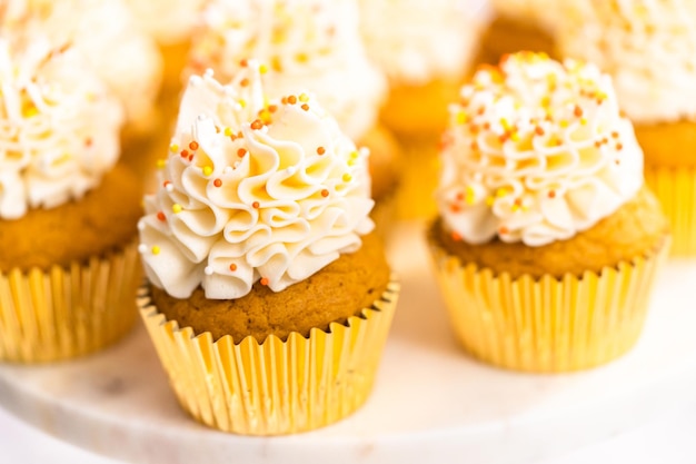 Pumpkin Spice Cupcake mit italienischer Buttercreme und Streuseln auf einem Tortenständer.