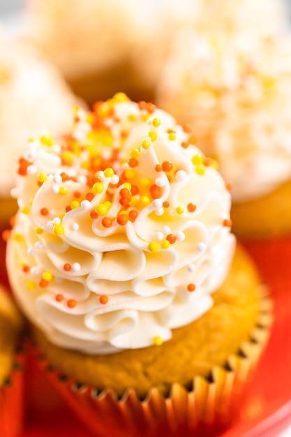 Pumpkin Spice Cupcake mit italienischer Buttercreme und Streuseln auf einem Tortenständer.