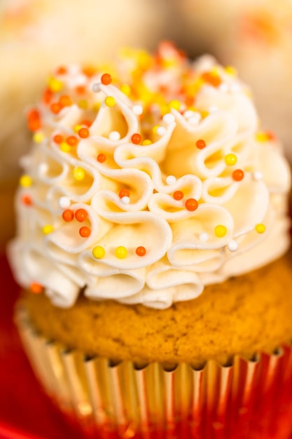 Pumpkin Spice Cupcake mit italienischer Buttercreme und Streuseln auf einem Tortenständer.