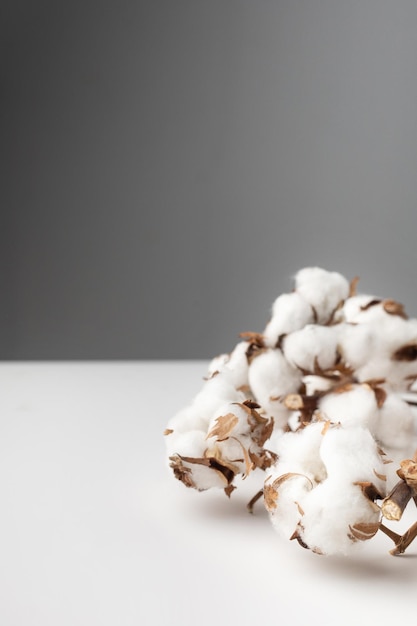 Un puñado de algodón sobre una mesa blanca sobre una macro de fondo gris