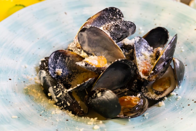 Un puñado de conchas de mejillones con queso parmesano