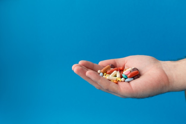 Un puñado de pastillas de colores en la palma. Médico. Compras en la farmacia.