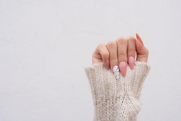 Punho de mulher com unhas pintadas de rosa esculpidas