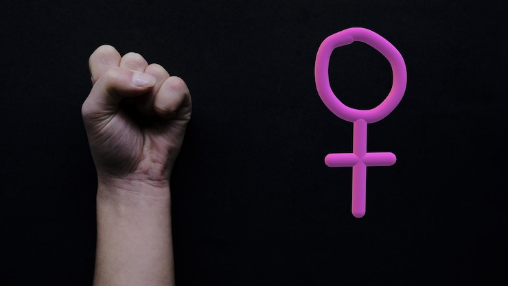 Foto punho levantado em um fundo preto em protesto contra a desigualdade em relação às mulheres. signo feminino. feminismo