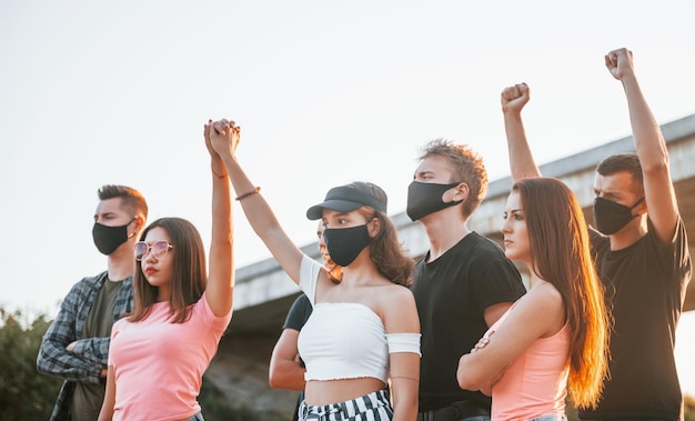 Punhos erguidos no alto Grupo de jovens protestando que se unem Ativista pelos direitos humanos ou contra o governo