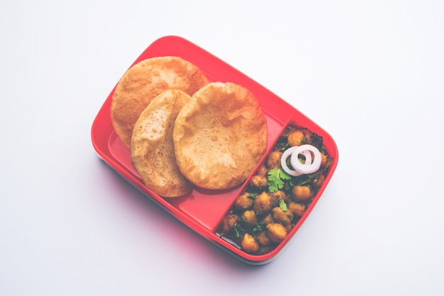 Punjabi Chole o Choley masala con puri o poori en lonchera o tiffin, enfoque selectivo