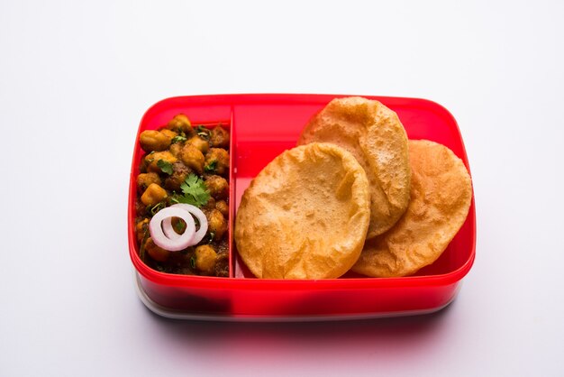 Punjabi Chole ou Choley masala com puri ou poori na lancheira ou tiffin, foco seletivo