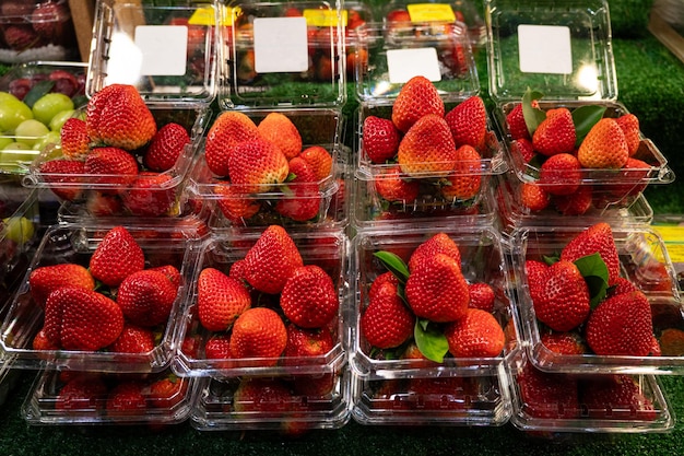 Punnet de fresas en recipientes de plástico para la venta en un mercado local.