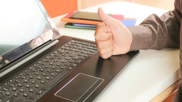 Puño de mano con laptop para trabajo de buen negocio.