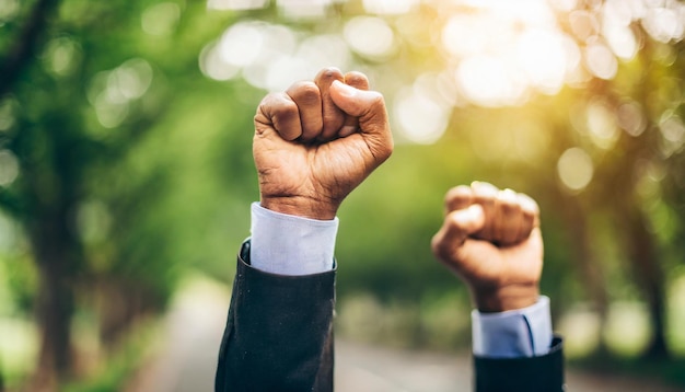 Puños levantados en unidad por la igualdad que simboliza la fuerza, la solidaridad y la lucha contra la injusticia.