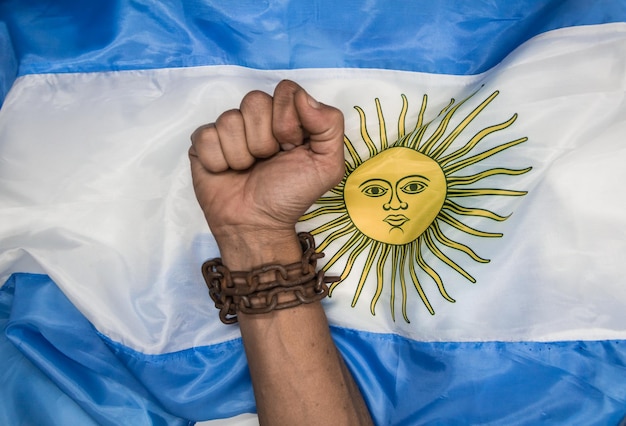 Foto puños que rompen las cadenas en la bandera argentina revolución argentina y concepto de independencia