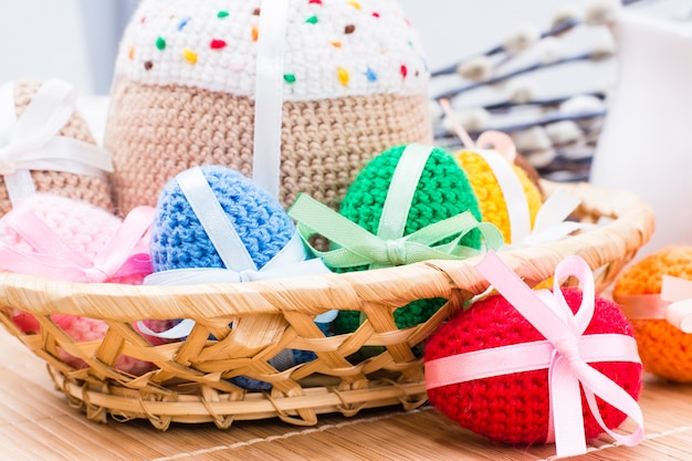 Punto de huevos de Pascua y pastel de Pascua en una cesta en una mesa de madera. Pascua bodegón