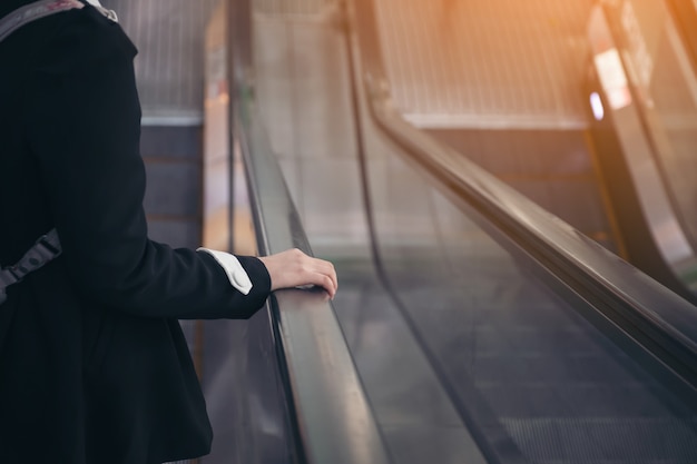 Punto de vista de una mujer montada en una escalera mecánica.