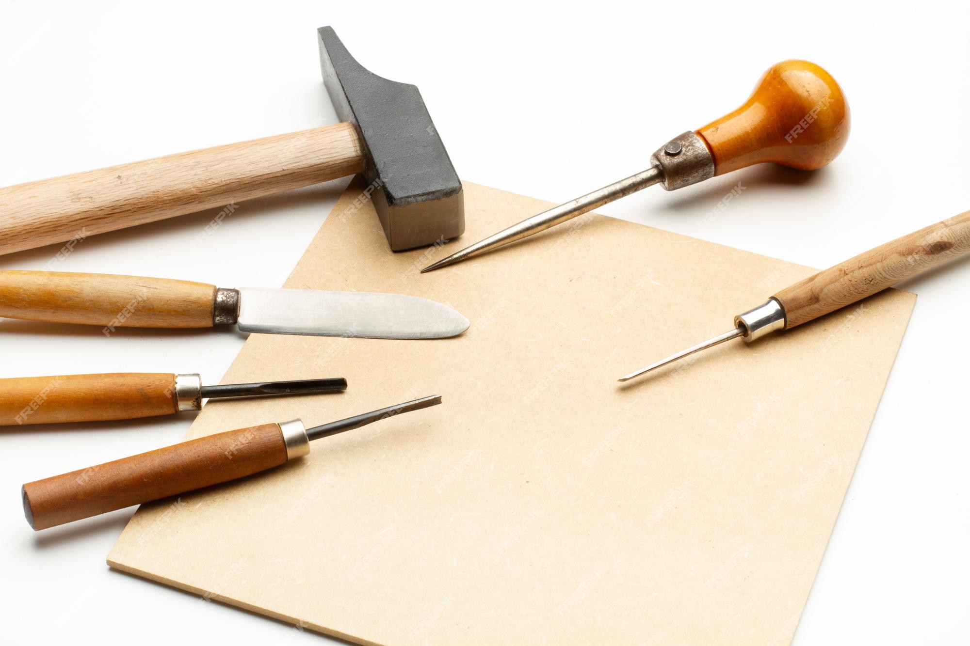 Punzón de martillo y gubias con mangos de madera sobre piezas de y sobre un fondo blanco. | Foto Premium