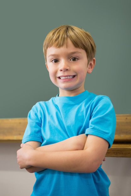 Pupila feliz sorrindo na câmera na sala de aula