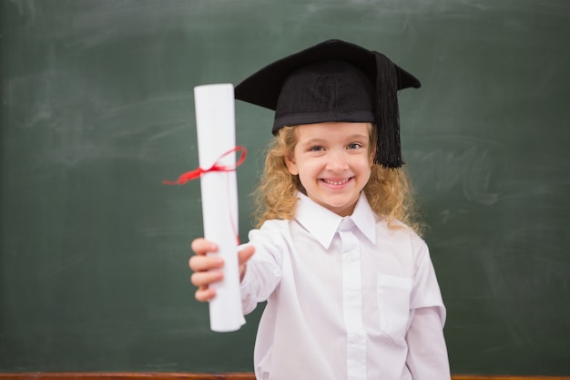 Pupila con sombrero de graduación y sosteniendo su diploma