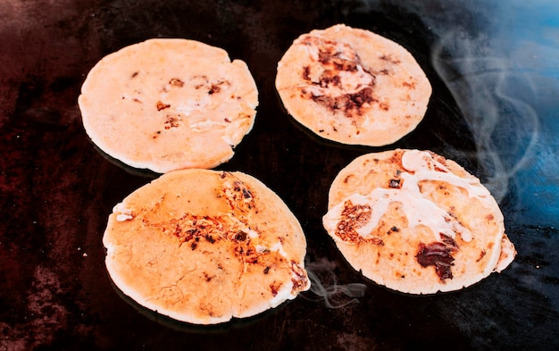 Pupusas tradicionales de queso a la parrilla Vista superior de cuatro pupusas tradicionales hechas a mano a la parrilla Pupusas tradicionales salvadoreñas con queso derretido a la parrilla