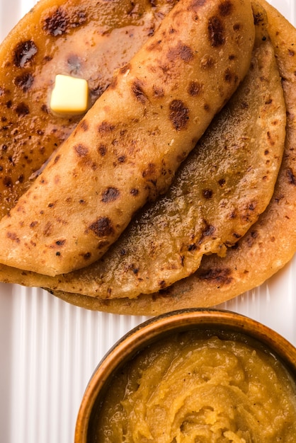 Puran Poli, también conocido como Holige, es un pan plano dulce indio que se consume principalmente durante el festival Holi. Servido en un plato con Ghee puro sobre fondo de colores o madera