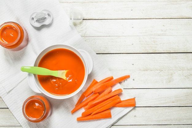 Puré de bebé de zanahorias frescas con una cuchara.