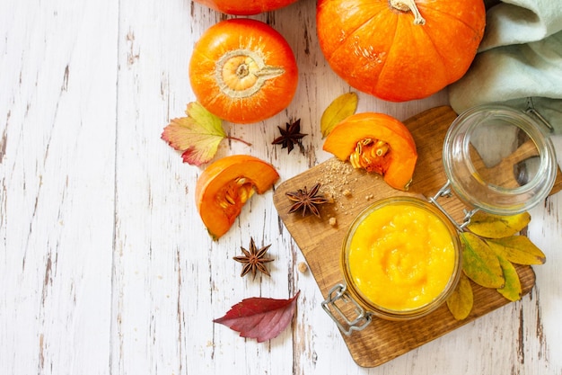 Puré de calabaza con especias y calabaza en una mesa de madera Vista superior fondo plano Espacio de copia