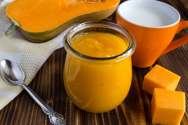 Foto puré de calabaza y taza de leche en el fondo de madera