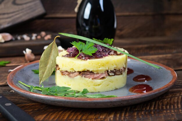 Purê de batata com carne de vaca, cebola caramelizada e molho de cereja